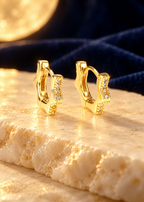 Styled editorial image of Starburst Huggie Hoops; AI-created setting. Original product photo also included.