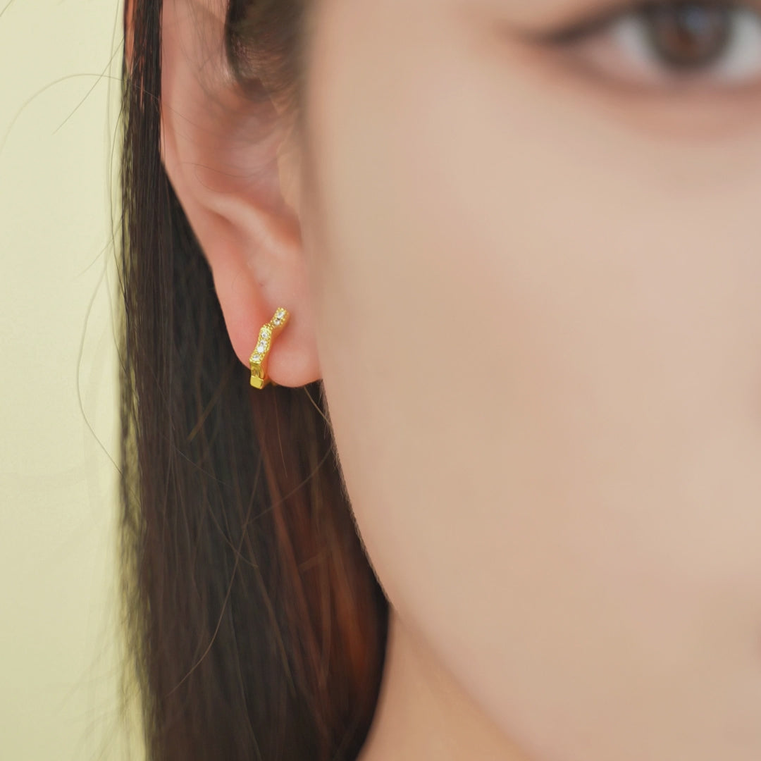 Starburst Huggie Hoops shown worn in motion.